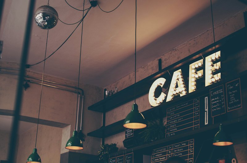Warmly lit cafe interior with a counter and pendant lights
