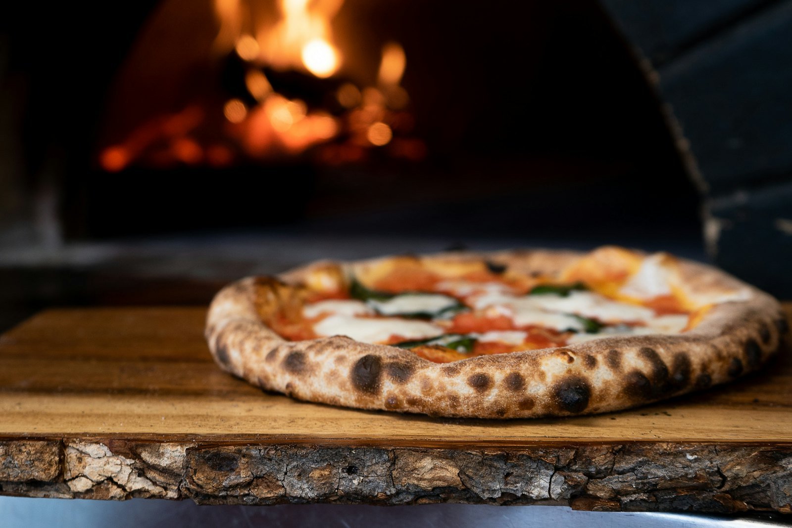 Wood-fired pizza fresh out of a glowing oven